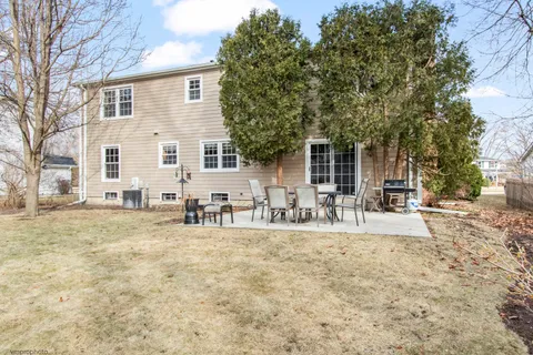 a view of house with yard and sitting area