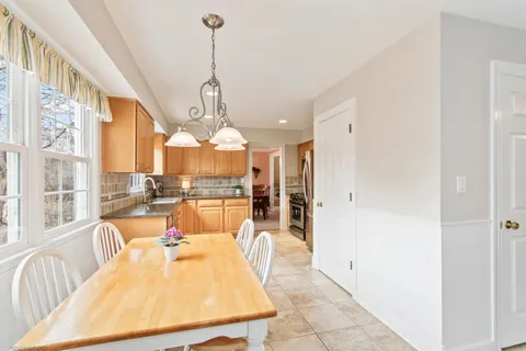 a dining room with furniture a chandelier and wooden floor