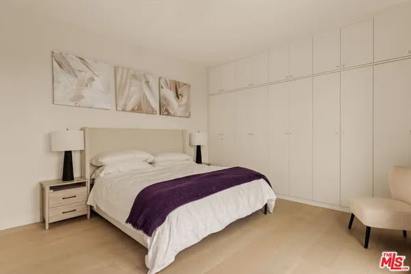 a bedroom with a bed and a painting on the wall