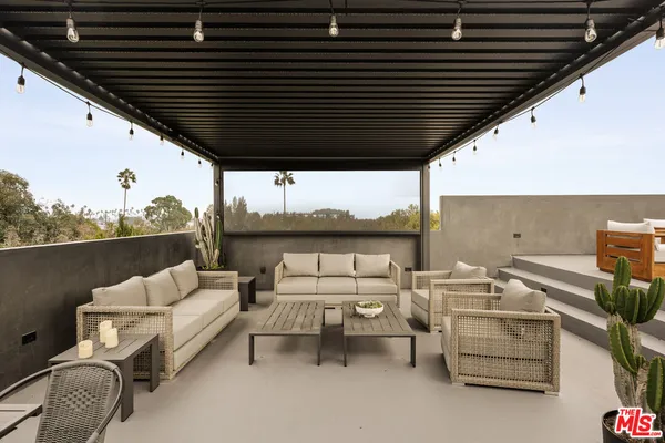 a roof deck with couch and chairs