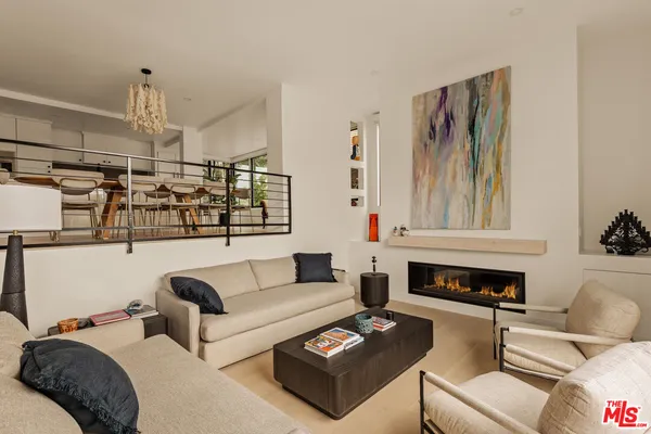 a living room with furniture kitchen view and a fireplace