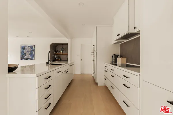 a large white kitchen with cabinets