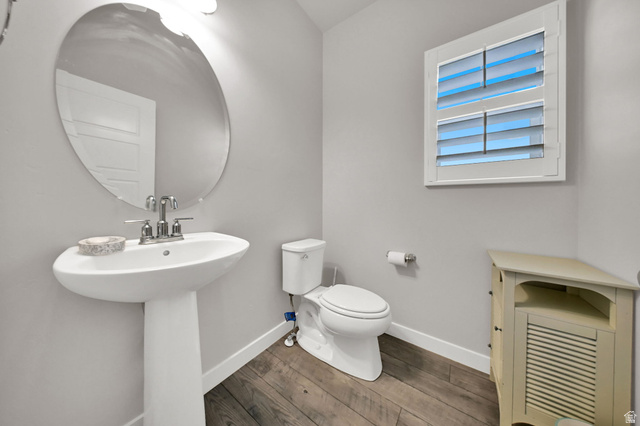 7817 West Kings Top Road Magna, UT 84044 - Photo 12 of 29 Half Bath, Pedestal sink with chrome-finish faucet, oval wall mirror, and wood-finish flooring