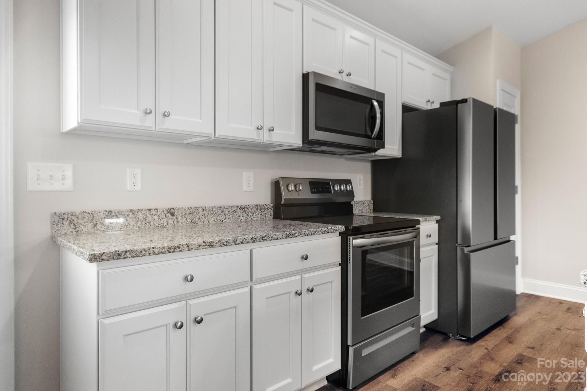 1509 Rehobeth Church Road Shelby, NC 28150 - Photo 11 of 34 a kitchen with stainless steel appliances granite countertop a refrigerator stove a sink and dishwasher with wooden floor