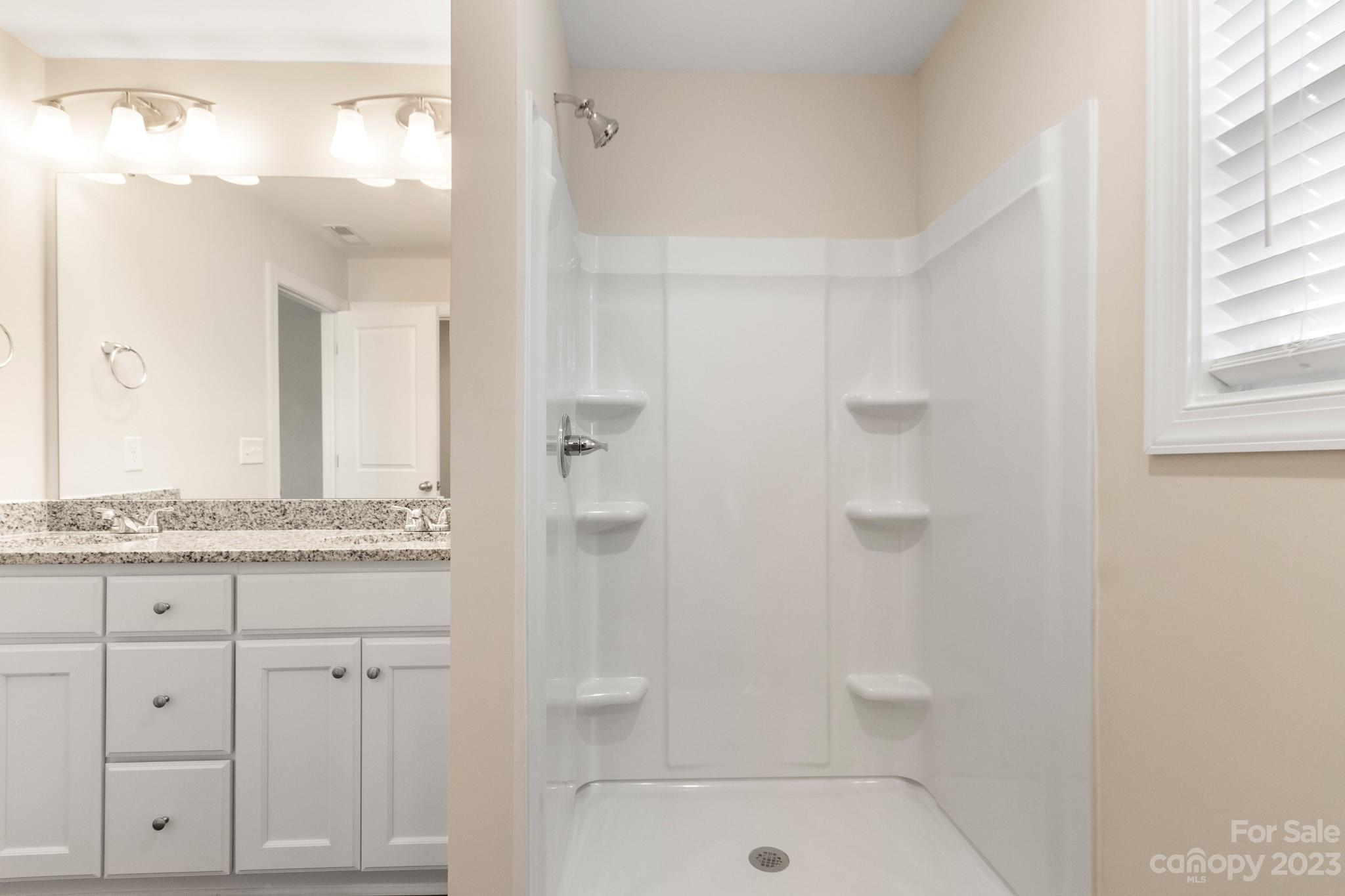 1509 Rehobeth Church Road Shelby, NC 28150 - Photo 21 of 34 a bathroom with a granite countertop sink a toilet a mirror and shower