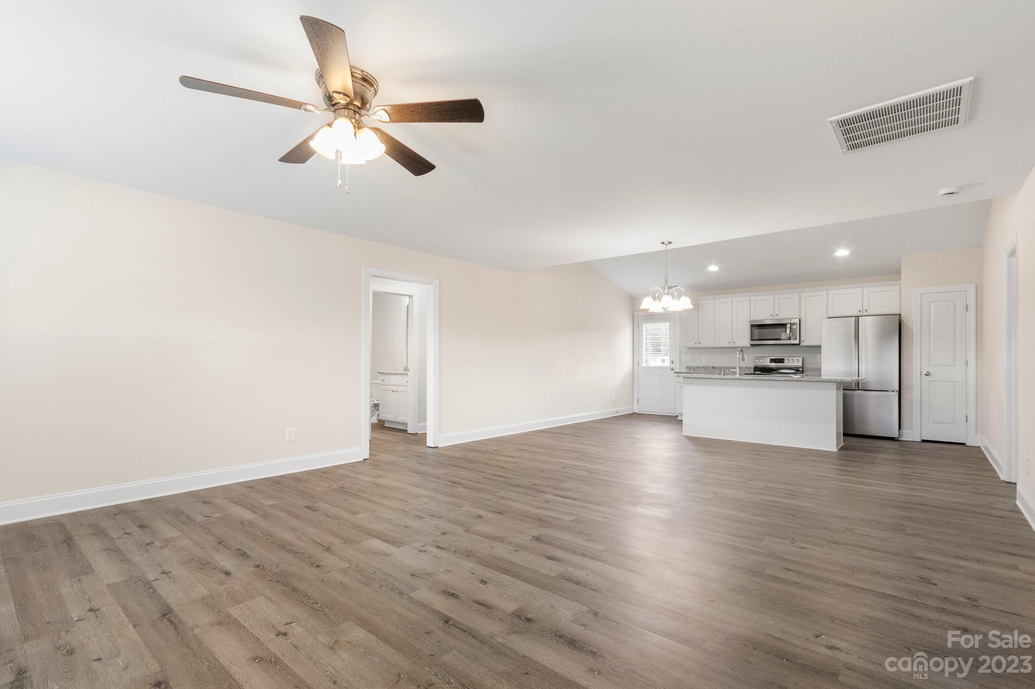 1509 Rehobeth Church Road Shelby, NC 28150 - Photo 6 of 34 a view of an empty room with wooden floor and a ceiling fan