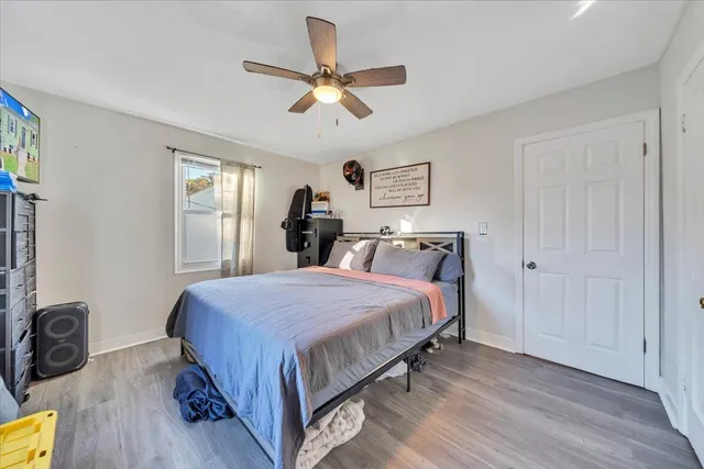 a bedroom with a bed a dresser and a window