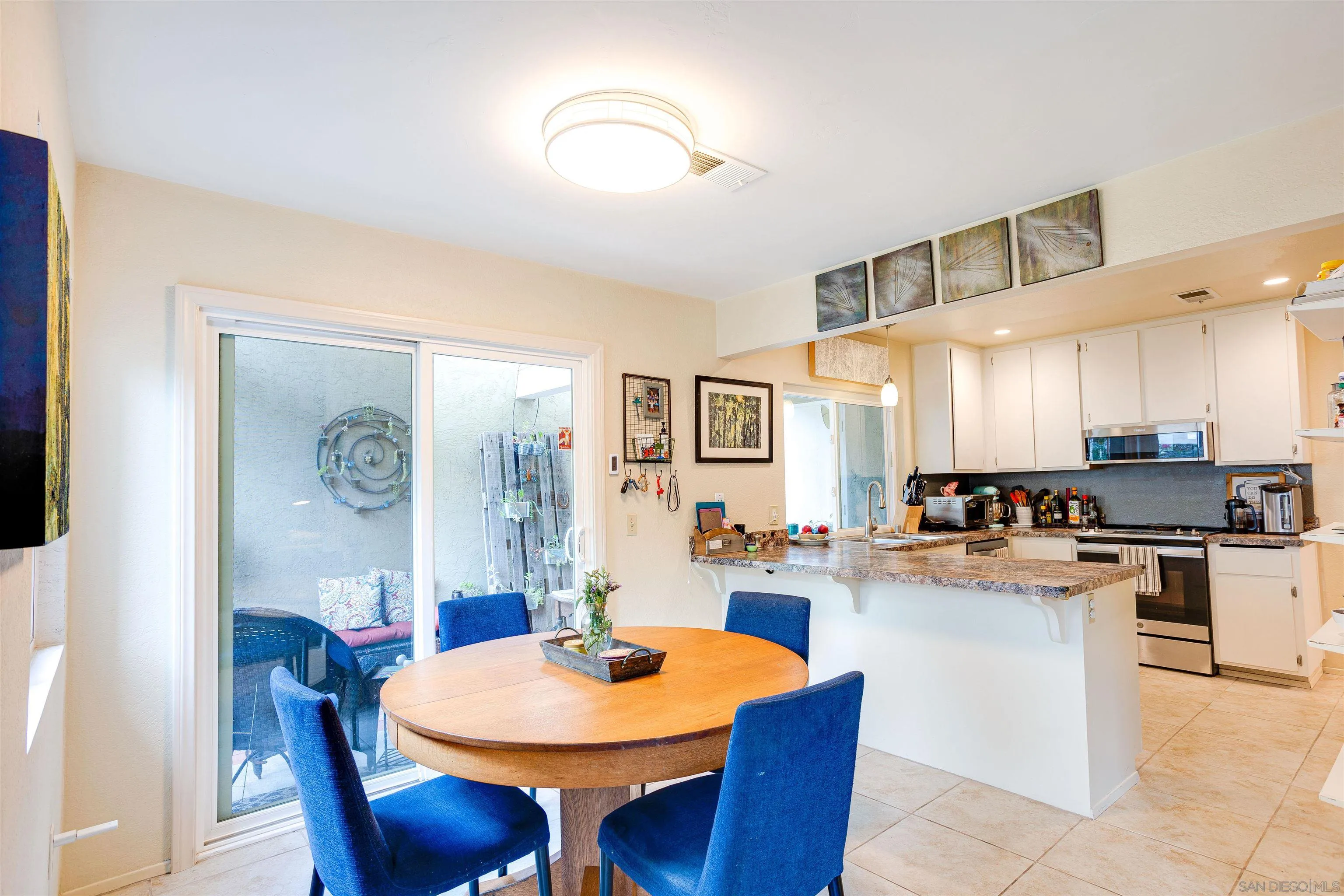 13657 Comuna Drive Poway, CA 92064 - Photo 4 of 36 a kitchen with a dining table chairs and stainless steel appliances