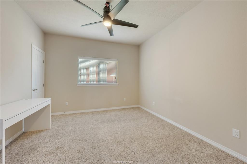 1198 Jones-Butler Road, Unit 2204 College Station, TX 77840 - Photo 5 of 8 an empty room with a chandelier fan and windows