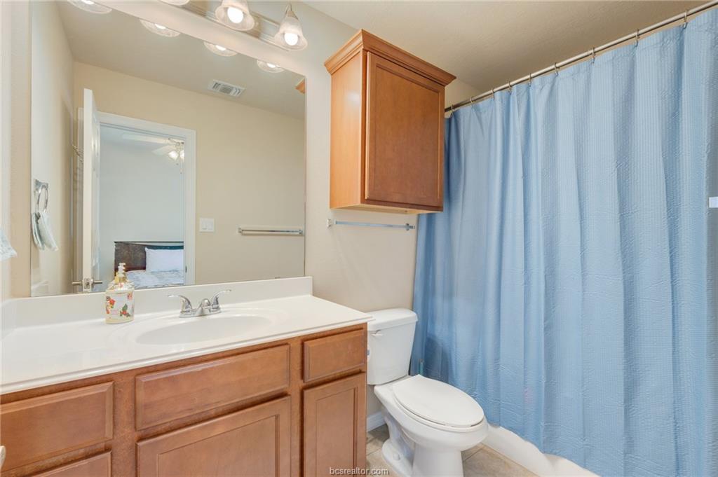 1198 Jones-Butler Road, Unit 2204 College Station, TX 77840 - Photo 7 of 8 a bathroom with a sink a toilet a mirror and shower curtain