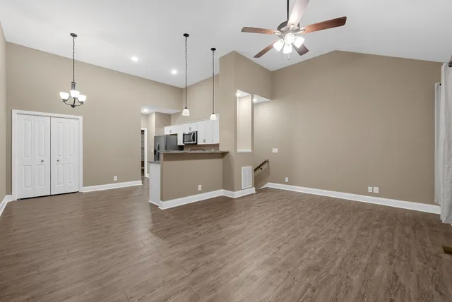 a view of a kitchen with a refrigerator a ceiling fan and a kitchen view