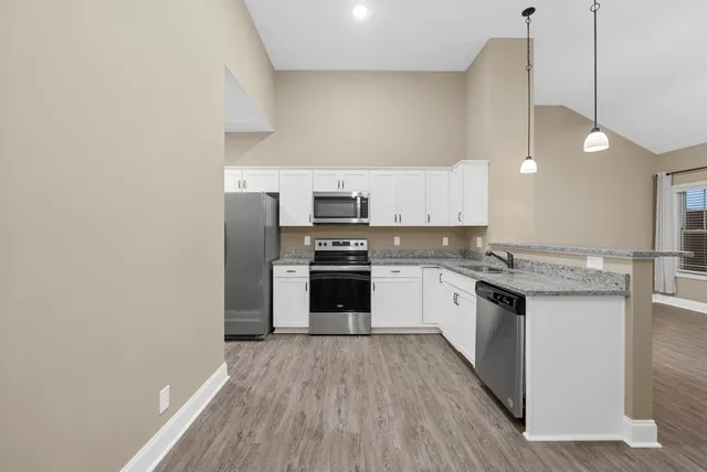 a kitchen with stainless steel appliances granite countertop a stove a sink and a refrigerator