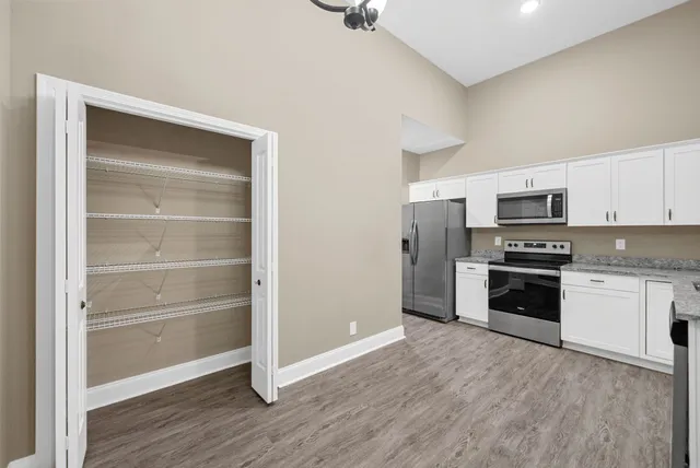 a kitchen with granite countertop a refrigerator and a stove top oven