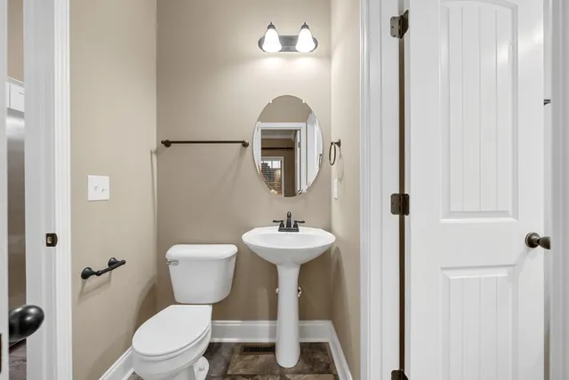 a bathroom with a toilet sink and mirror