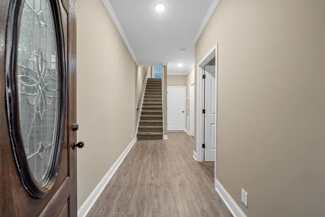 a view of a hallway with wooden floor and staircase