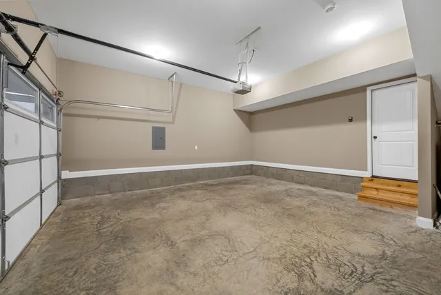 an empty room with an entryway and chandelier