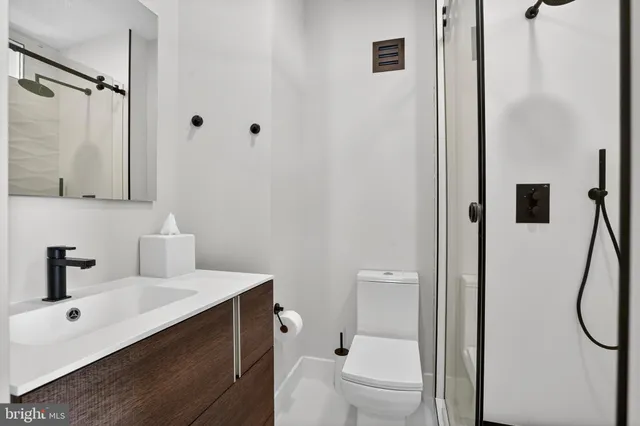 a bathroom with a sink a toilet and shower