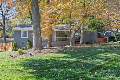 front view of a house with a tree and a yard