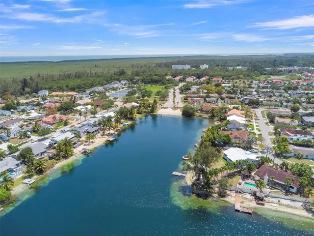 an aerial view of a city with lots of residential buildings ocean and mountain view in back
