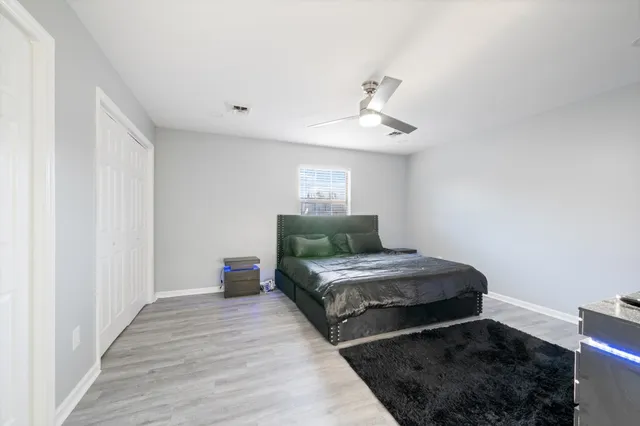 a bedroom with a large bed and a chandelier