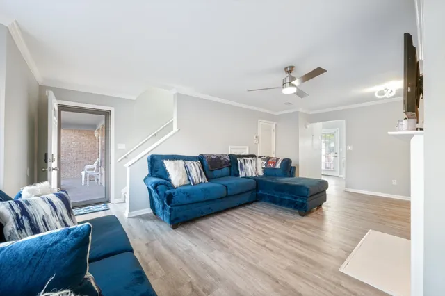 a living room with furniture and a wooden floor