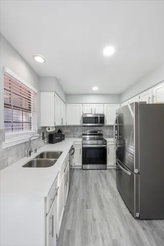 a kitchen with kitchen island granite countertop a sink cabinets and stainless steel appliances