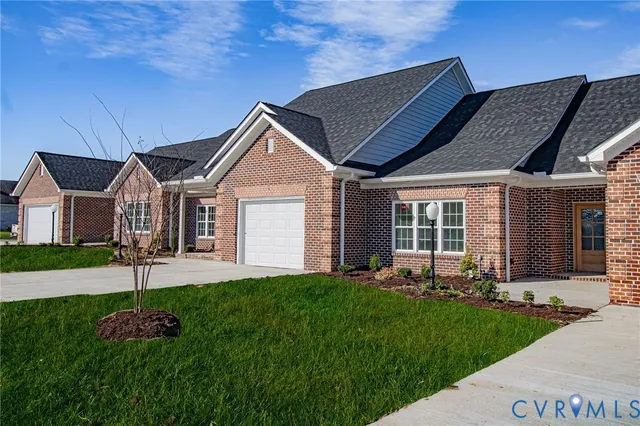 a front view of a house with a garden and yard