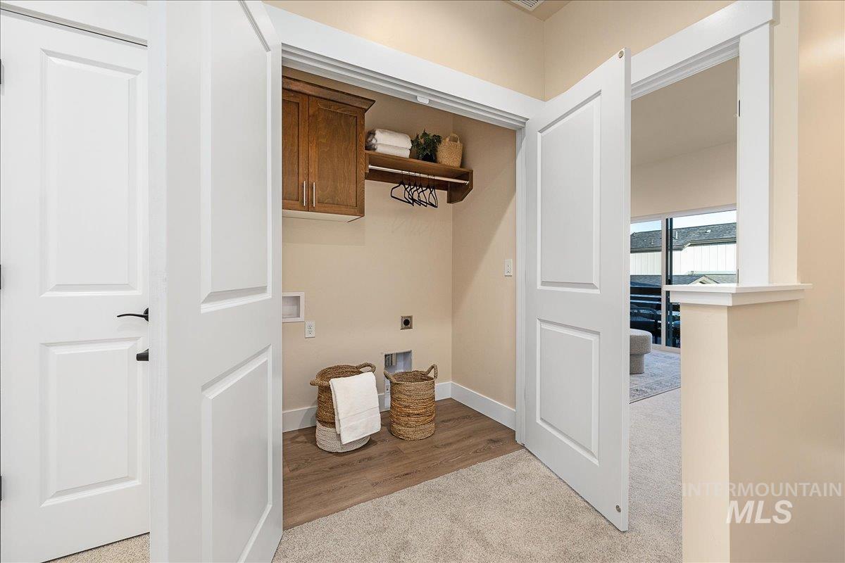 1445 North Bluffs Ridge Lane Boise, ID 83704 - Photo 40 of 47 Laundry room featuring electric dryer hookup, hookup for a washing machine, light carpet, and cabinet space