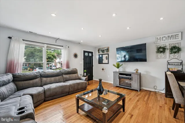 a living room with furniture flat screen tv and wooden floor
