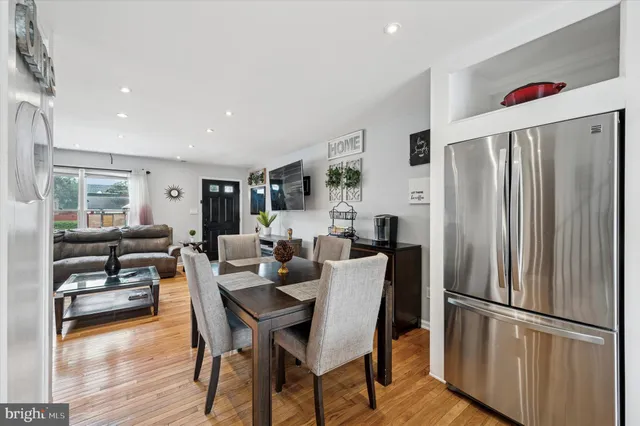 a living room with furniture wooden floor and a refrigerator