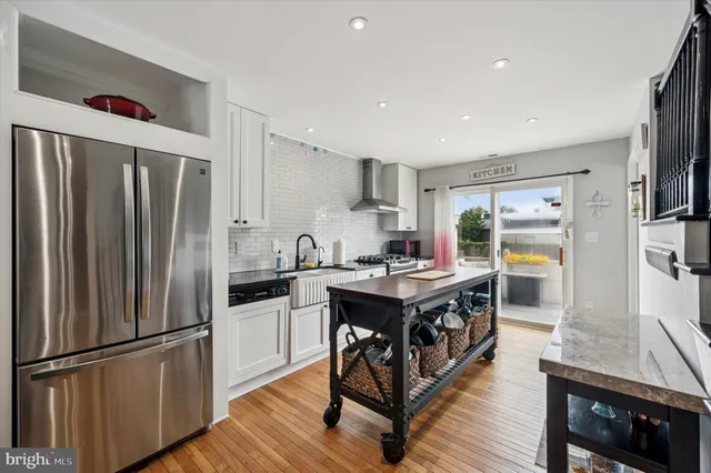 a kitchen with kitchen island a counter top space a sink stainless steel appliances and cabinets