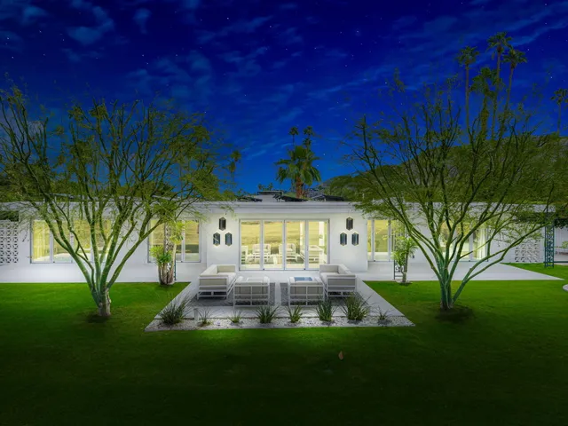 a view of a house with backyard and sitting area