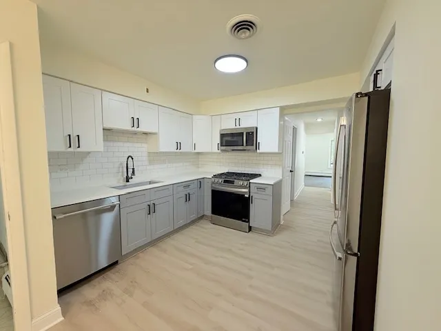 a kitchen with a refrigerator sink and cabinets