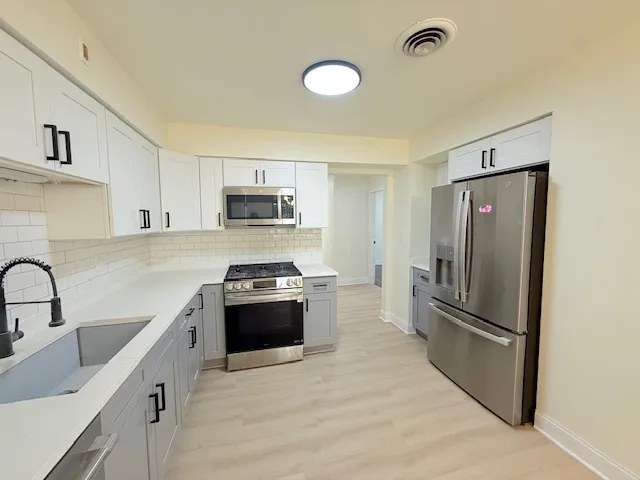 a kitchen with granite countertop a refrigerator stove and sink