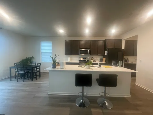 a kitchen with kitchen island a sink table and chairs