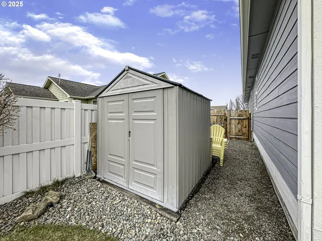 a view of a chair and table in backyard of the house
