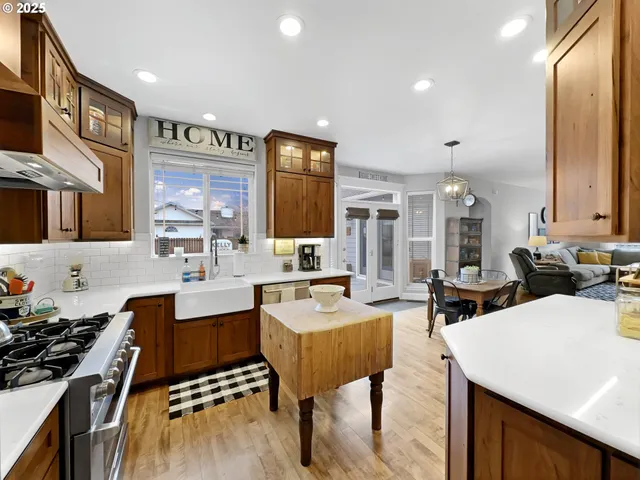 a large kitchen with stainless steel appliances a stove a sink dishwasher and cabinets with wooden floor