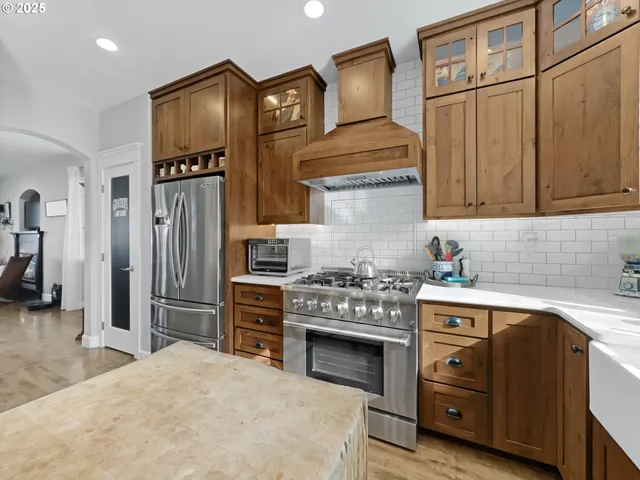 a kitchen with stainless steel appliances granite countertop a stove a refrigerator and a sink