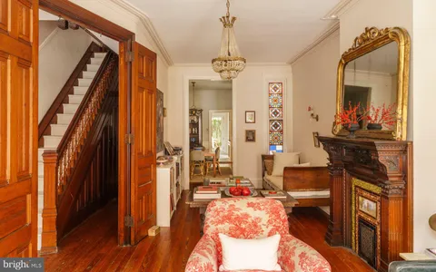 a living room with furniture a bookshelf and a window