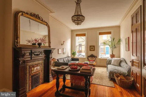 a living room with furniture a fireplace and a chandelier
