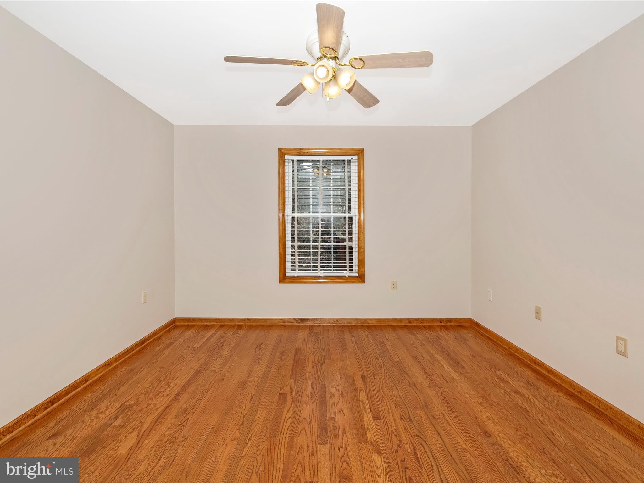 4439 John Draper Road Smithsburg, MD 21783 - Photo 38 of 63 a view of a room with wooden floor a ceiling fan and windows