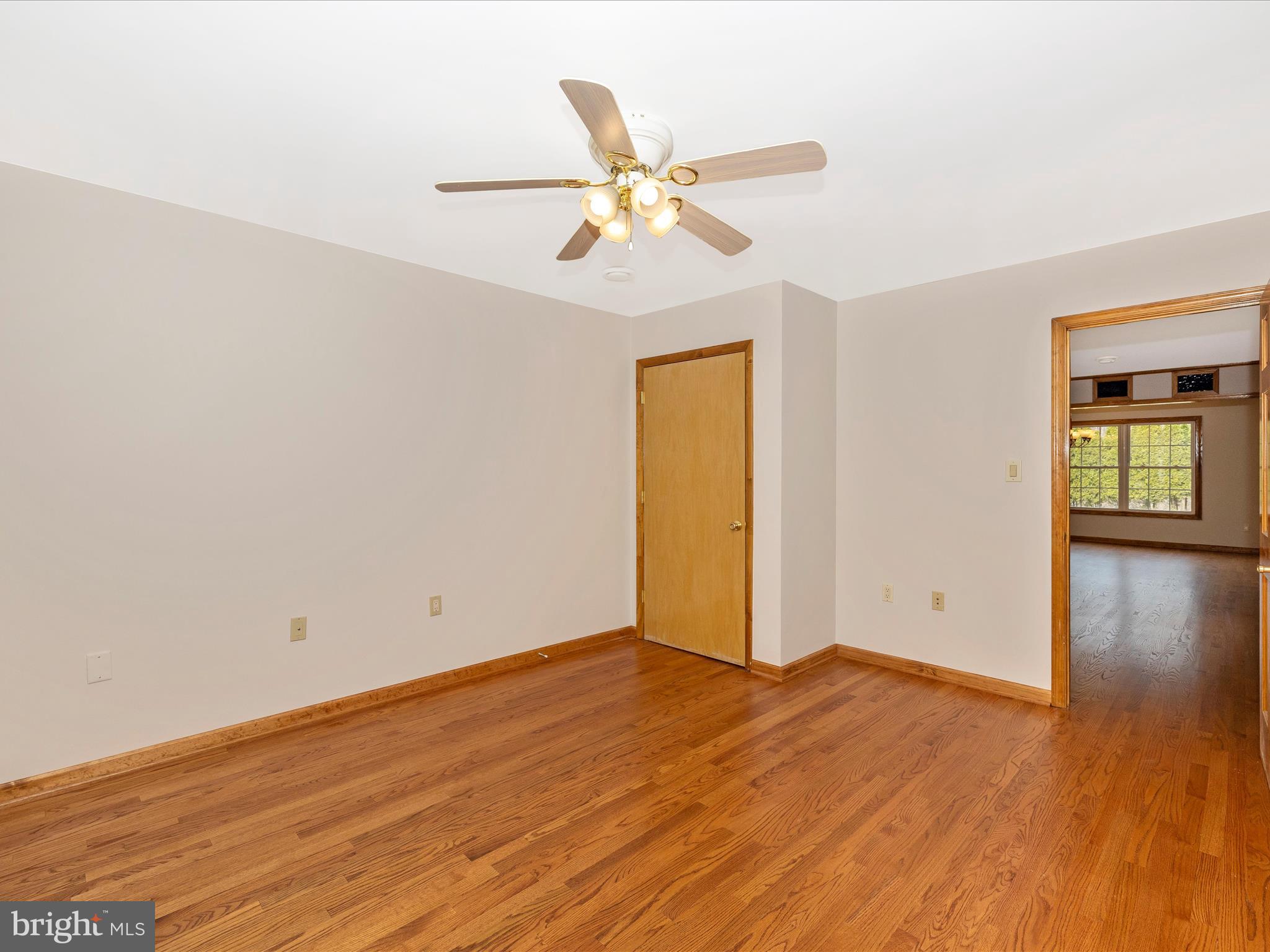 4439 John Draper Road Smithsburg, MD 21783 - Photo 39 of 63 an empty room with wooden floor chandelier fan and windows