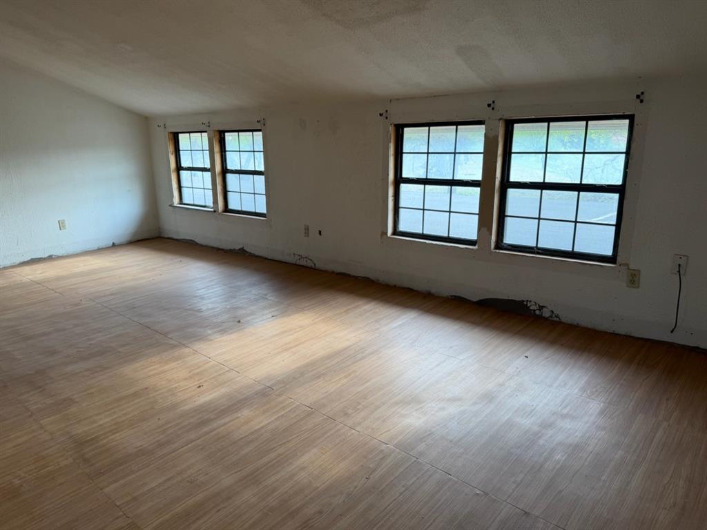 4050 Old Anson Road Abilene, TX 79601 - Photo 8 of 40 an empty room with wooden floor and windows