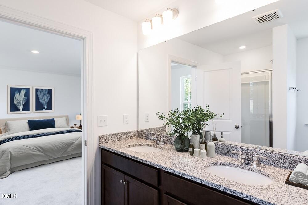 247 Blue Butterfly Drive Angier, NC 27501 - Photo 10 of 41 a bathroom with a granite countertop sink and a mirror