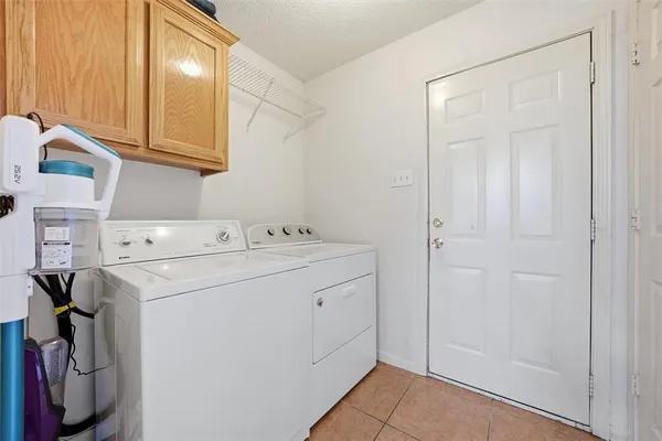 a utility room with cabinets washer and dryer