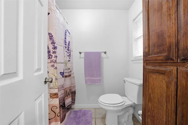 a white toilet sitting next to a shower curtain