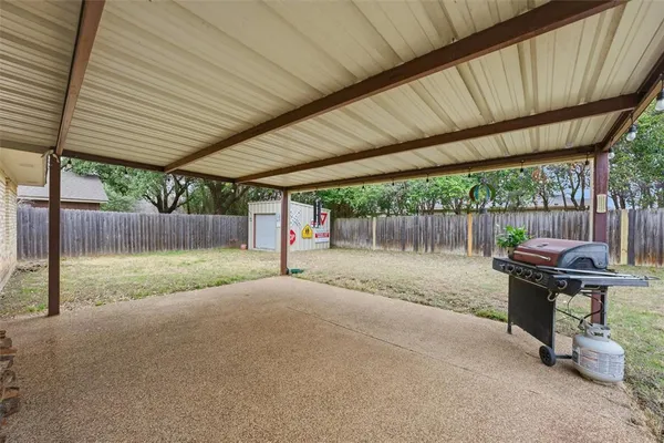 a view of backyard with table and chairs and wooden fence