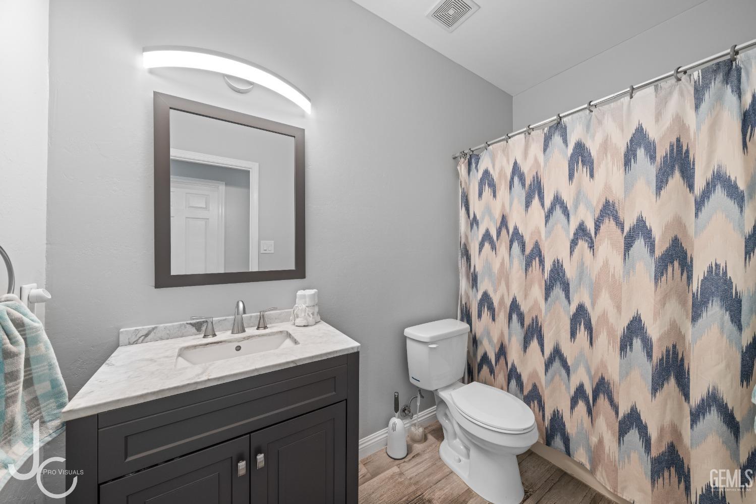 Undisclosed Address Bakersfield, CA 93307 - Photo 17 of 31 a bathroom with a granite countertop sink and a toilet
