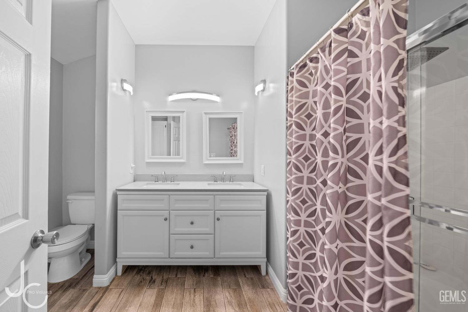 Undisclosed Address Bakersfield, CA 93307 - Photo 22 of 31 a bathroom with a granite countertop sink a toilet and a mirror