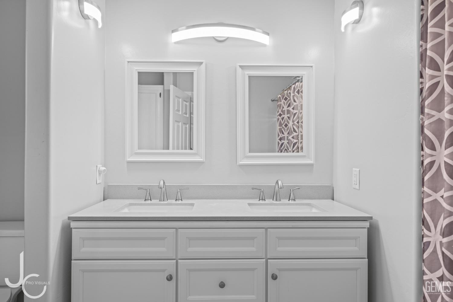 Undisclosed Address Bakersfield, CA 93307 - Photo 23 of 31 a bathroom with a double vanity sink and a mirror